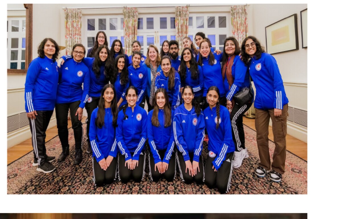 Group photo of a delegation in matching blue jackets